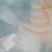 Decorative hair clip with floral design held by a hand against a light background